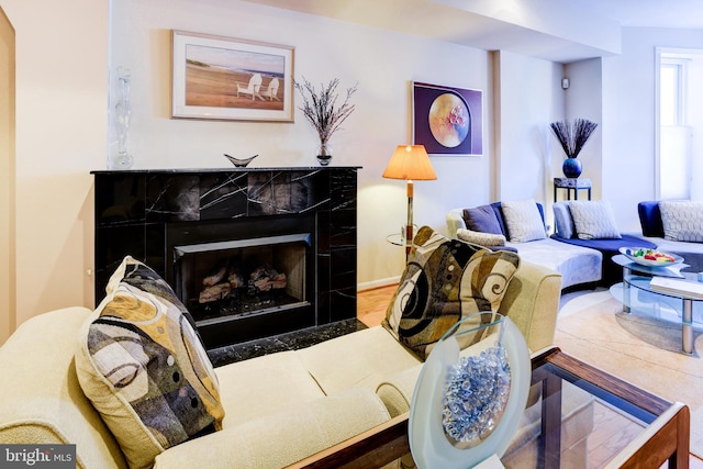 living room with wood-type flooring and a tile fireplace