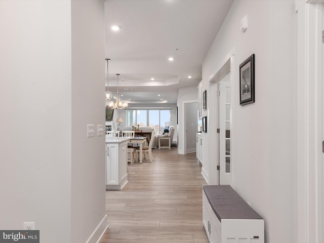 hallway featuring a chandelier and light wood-type flooring