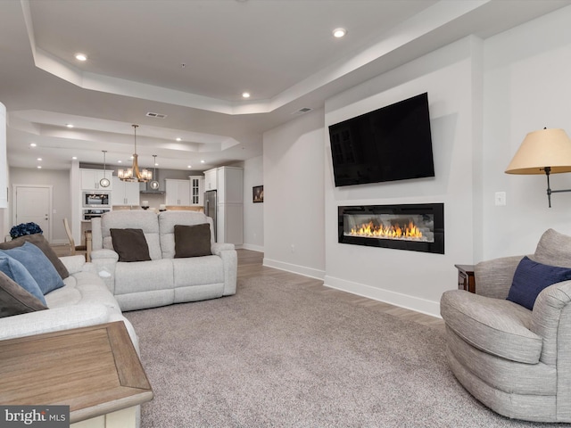 200 Harrier Way Unit 42, Chester, MD 21619 - living room with a glass covered fireplace, a raised ceiling, baseboards, recessed lighting, and a chandelier