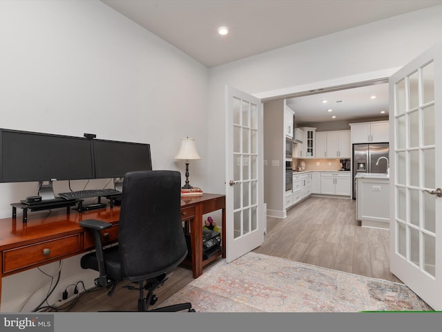 office space with french doors and light hardwood / wood-style floors