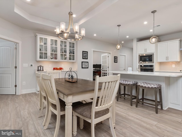 dining space featuring light hardwood / wood-style flooring and an inviting chandelier