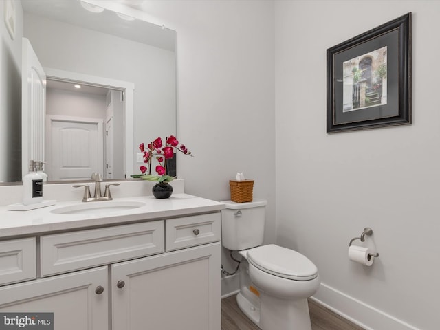 bathroom with vanity, toilet, and wood-type flooring