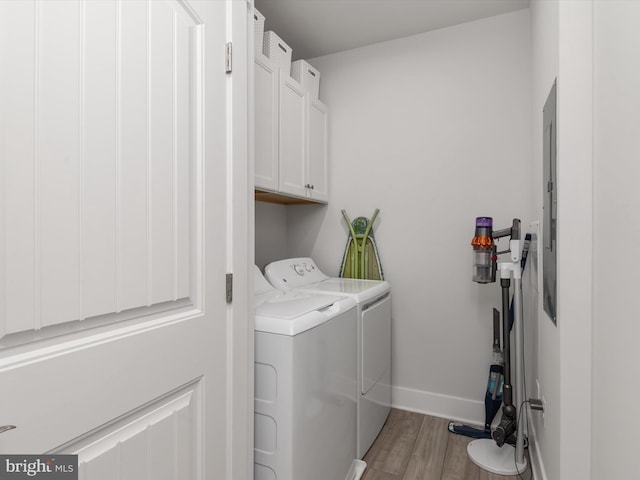 laundry area with light hardwood / wood-style floors, cabinets, and independent washer and dryer