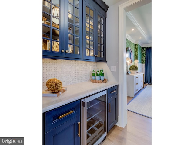 bar with blue cabinetry, light hardwood / wood-style flooring, and beverage cooler