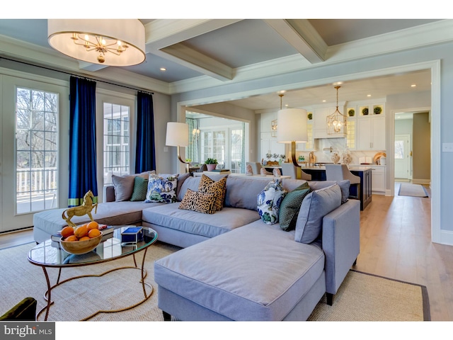 living room with a wealth of natural light, beamed ceiling, light hardwood / wood-style flooring, and crown molding