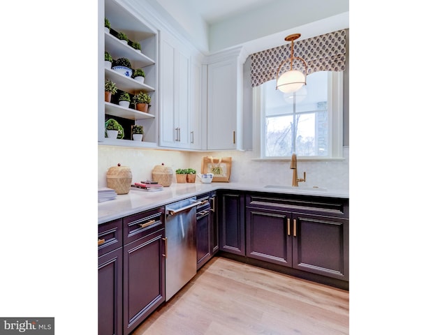 kitchen with light hardwood / wood-style floors, stainless steel dishwasher, sink, and backsplash