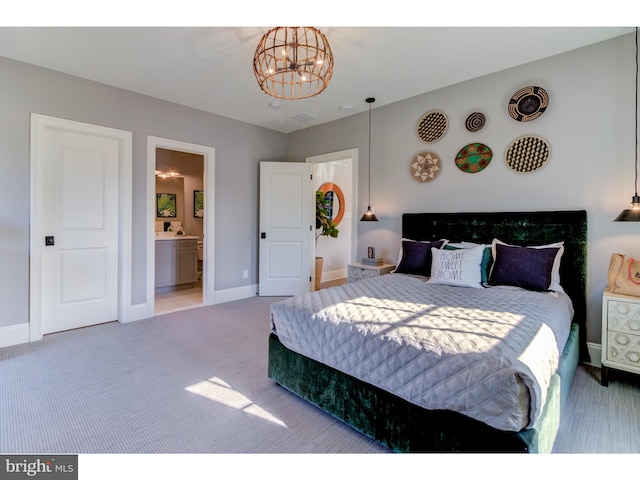 carpeted bedroom with ensuite bath and a chandelier