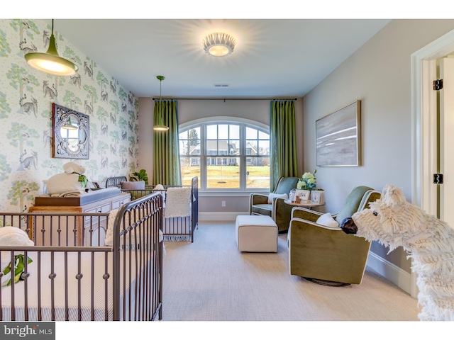 bedroom with carpet and a nursery area