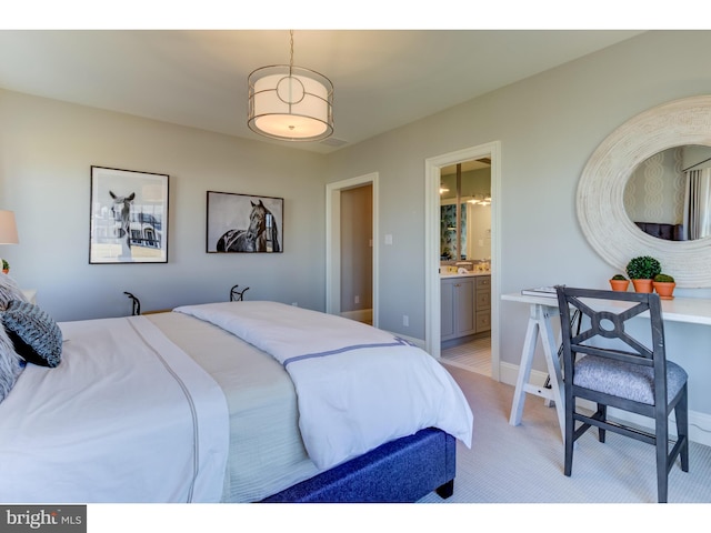 bedroom with light colored carpet and ensuite bath