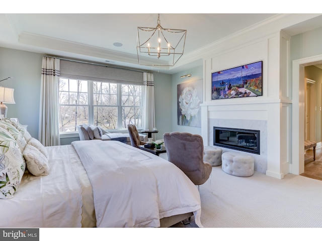 bedroom featuring crown molding, a raised ceiling, carpet floors, and a notable chandelier