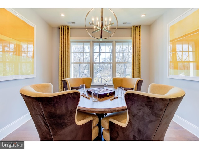 dining room featuring wood-type flooring and a chandelier