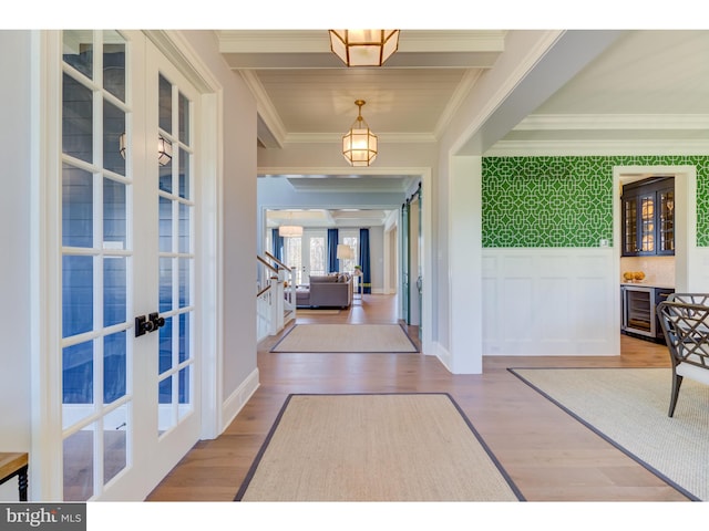 foyer featuring wine cooler, french doors, hardwood / wood-style flooring, and crown molding