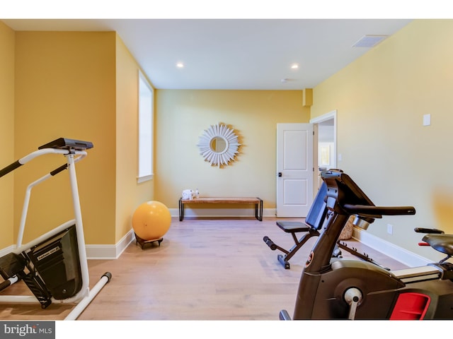 workout room with light hardwood / wood-style flooring