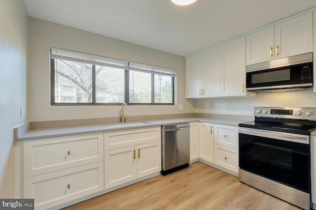 kitchen featuring white cabinetry, light hardwood / wood-style floors, appliances with stainless steel finishes, and sink