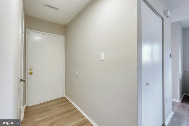 hallway with light hardwood / wood-style floors