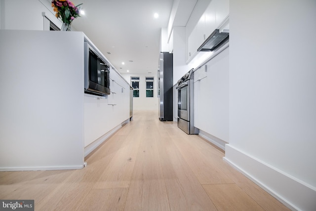 hallway featuring a barn door and light hardwood / wood-style floors