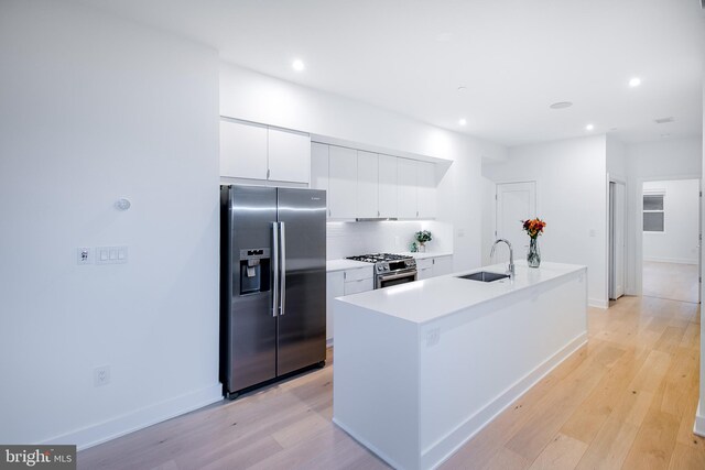 kitchen featuring sink, a kitchen island with sink, light hardwood / wood-style floors, and stainless steel appliances