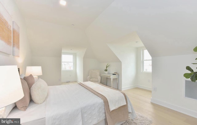 bedroom with lofted ceiling and light hardwood / wood-style floors