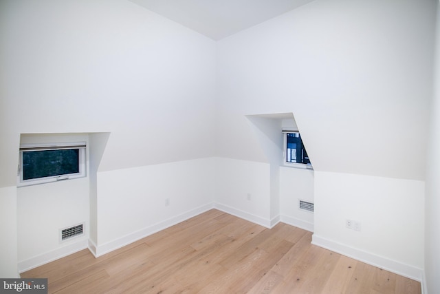 bonus room with hardwood / wood-style flooring and vaulted ceiling