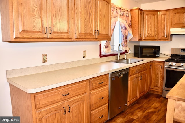 kitchen featuring stainless steel appliances, dark hardwood / wood-style floors, sink, and exhaust hood