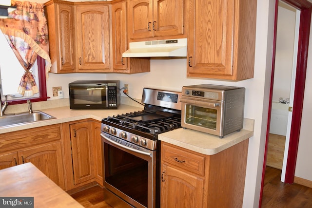 kitchen featuring stainless steel gas range oven and dark hardwood / wood-style floors