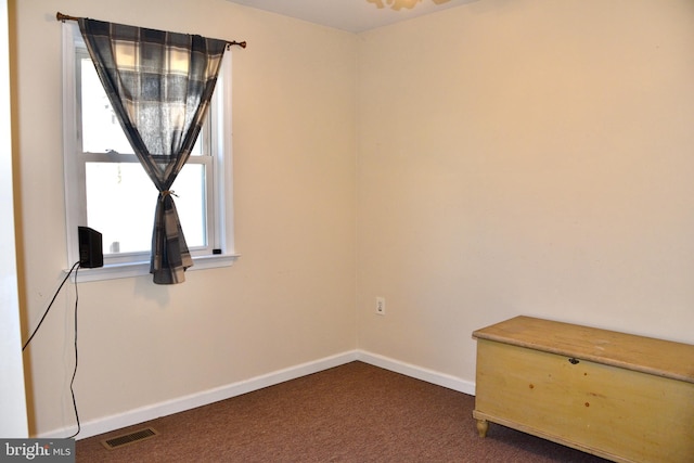 unfurnished room with dark carpet