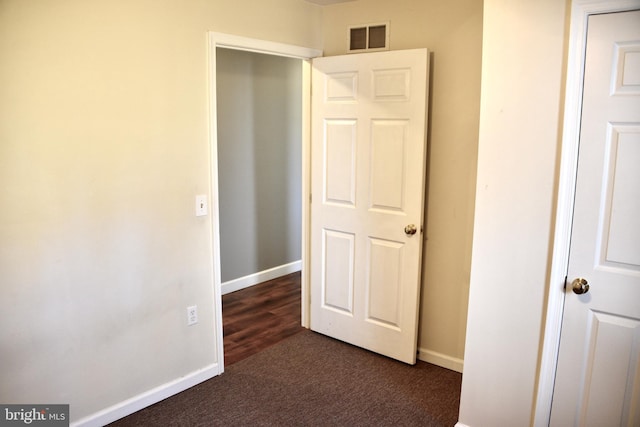 unfurnished bedroom with dark colored carpet