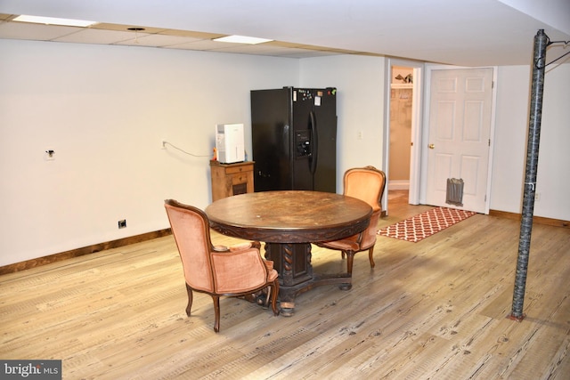 dining area featuring a paneled ceiling and light hardwood / wood-style floors