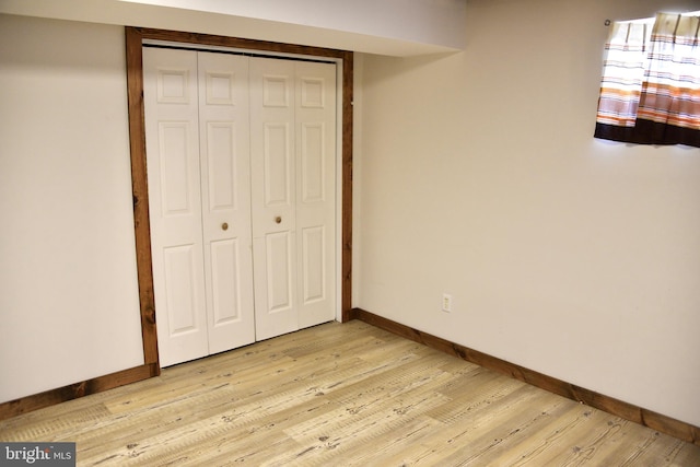 unfurnished bedroom with light hardwood / wood-style floors and a closet