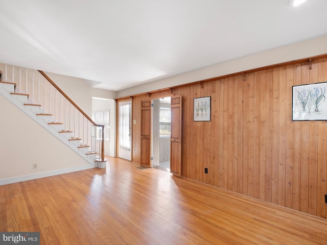 foyer featuring wooden walls and light wood-type flooring