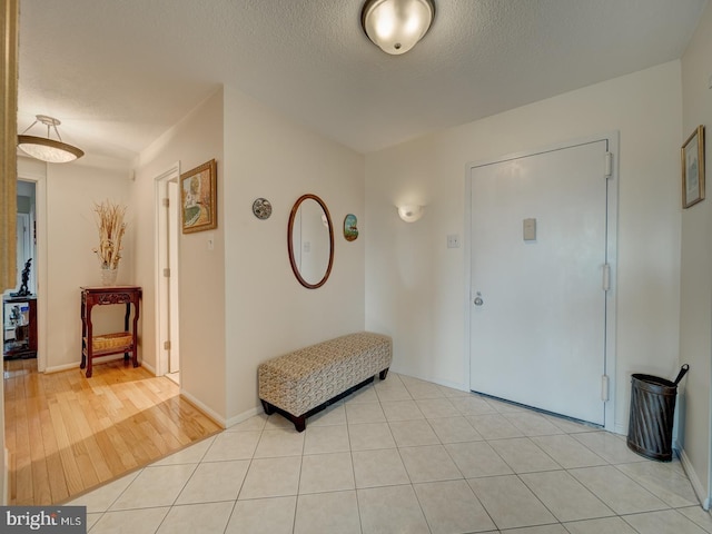 entrance foyer featuring light tile patterned floors and a textured ceiling