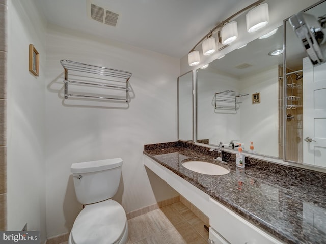 bathroom with a shower, vanity, toilet, and tile patterned floors