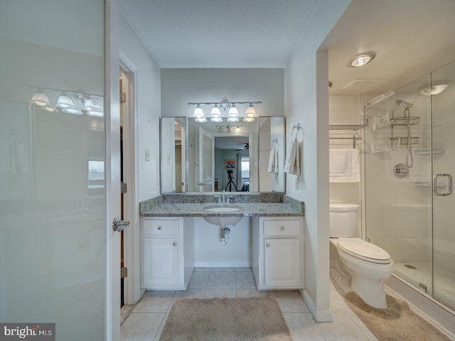 bathroom featuring tile patterned floors, toilet, sink, and walk in shower