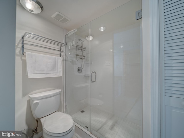 bathroom with toilet and a shower with door