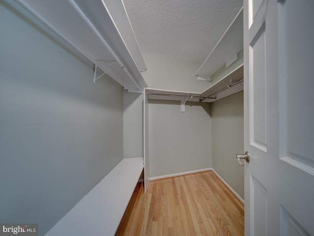 walk in closet with light hardwood / wood-style floors