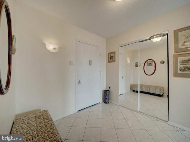 interior space featuring a textured ceiling and light tile patterned floors