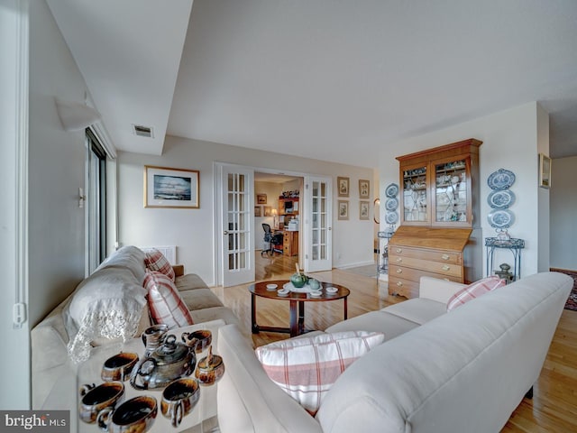 living room with light wood-type flooring and french doors