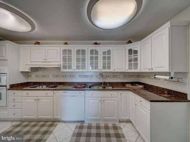 kitchen with light tile patterned flooring, sink, white appliances, and white cabinets