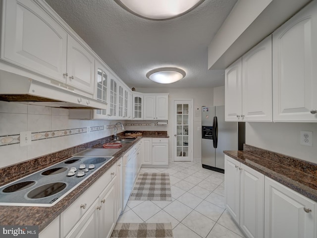 kitchen featuring white appliances, white cabinetry, sink, and a textured ceiling