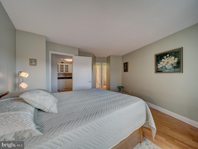 bedroom with sink and light hardwood / wood-style flooring