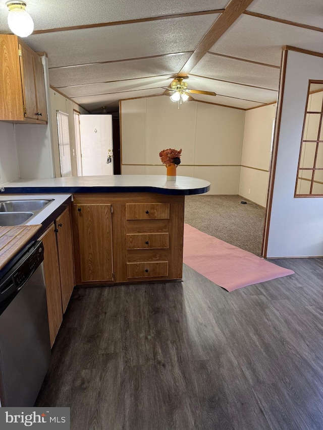 kitchen with stainless steel dishwasher, sink, dark hardwood / wood-style flooring, and a textured ceiling