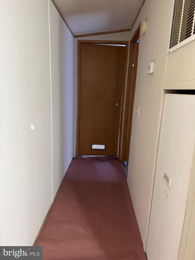 corridor with a textured ceiling, carpet, and lofted ceiling