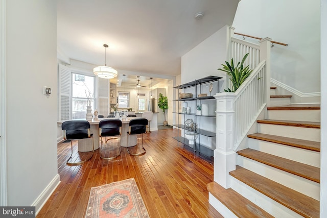 interior space featuring light hardwood / wood-style floors, ceiling fan, and decorative light fixtures