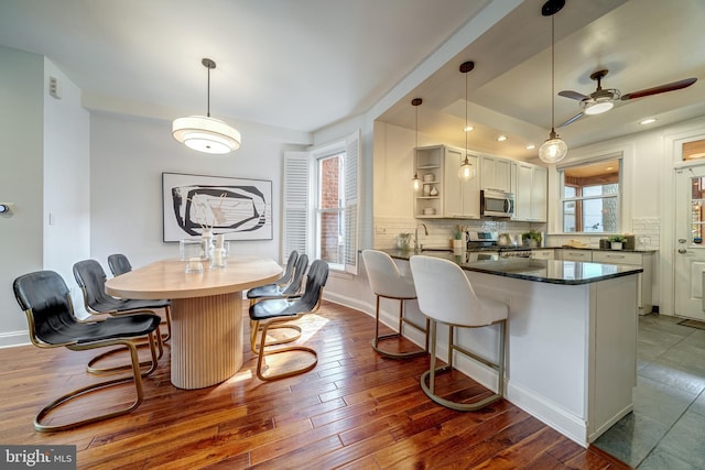 kitchen with pendant lighting, a healthy amount of sunlight, appliances with stainless steel finishes, and a breakfast bar area