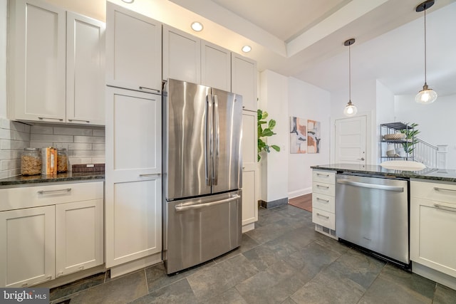 kitchen with white cabinetry, appliances with stainless steel finishes, dark stone countertops, backsplash, and decorative light fixtures