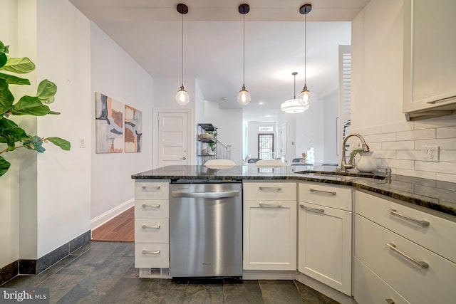 kitchen featuring hanging light fixtures, stainless steel dishwasher, sink, and dark stone countertops