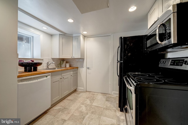 kitchen featuring white cabinetry, decorative backsplash, appliances with stainless steel finishes, and wooden counters