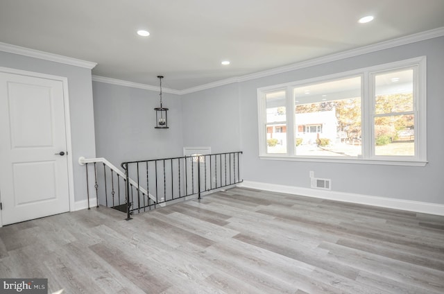 spare room with light hardwood / wood-style floors and ornamental molding