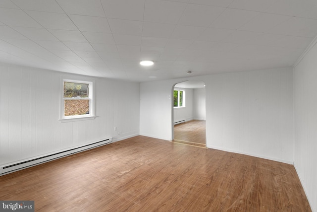 spare room with hardwood / wood-style flooring and a baseboard radiator