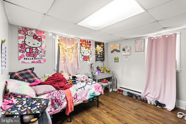 bedroom with a paneled ceiling and wood-type flooring